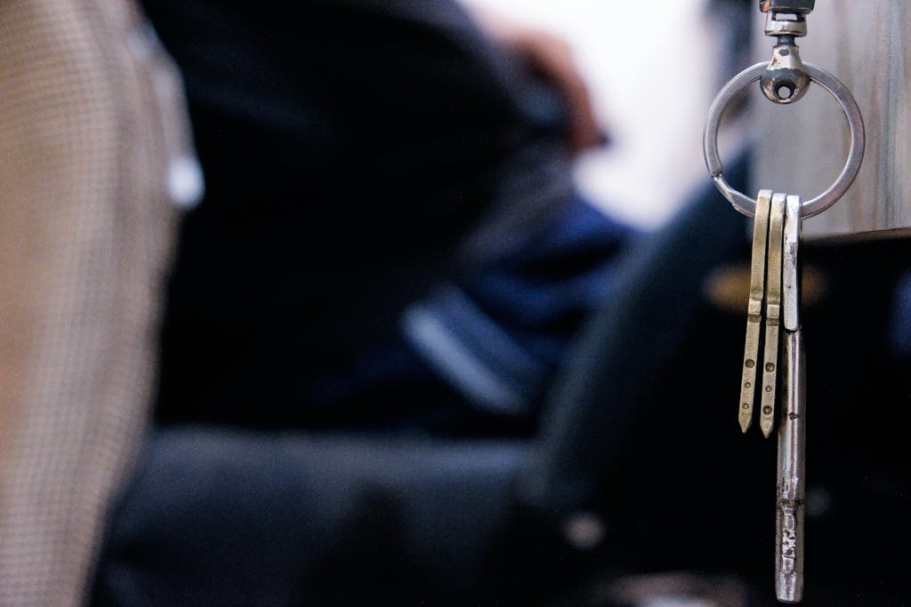 Detailed macro shot of metal keys hanging from a keychain indoors. 