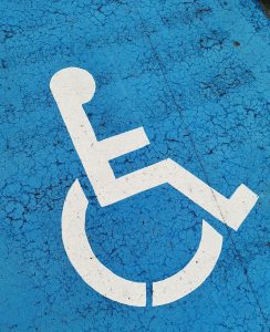 Parking space with wheelchair symbol on blue background for accessibility.