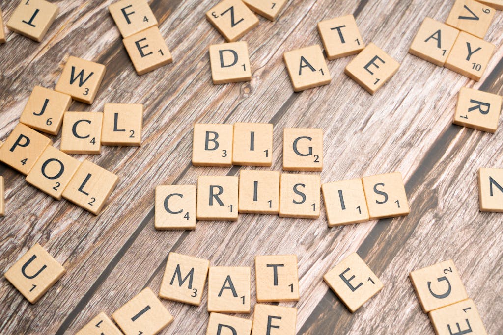 Wooden tiles forming the words 'Big Crisis' on a wooden background.
